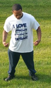 Man standing in field wearing I love where I'm from white t-shirt
