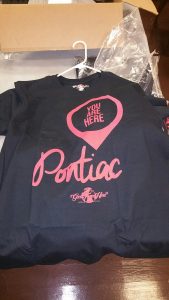 Black You are here Pontiac t-shirt on table