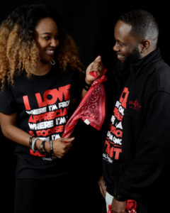 Man and woman standing looking at eachother wearing GearFromHere "I love where I'm from" clothing